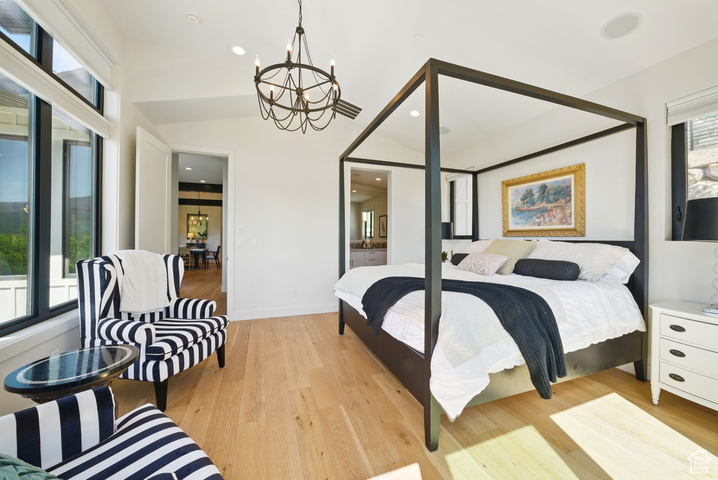 Bedroom with a chandelier, light wood-type flooring, and baseboards