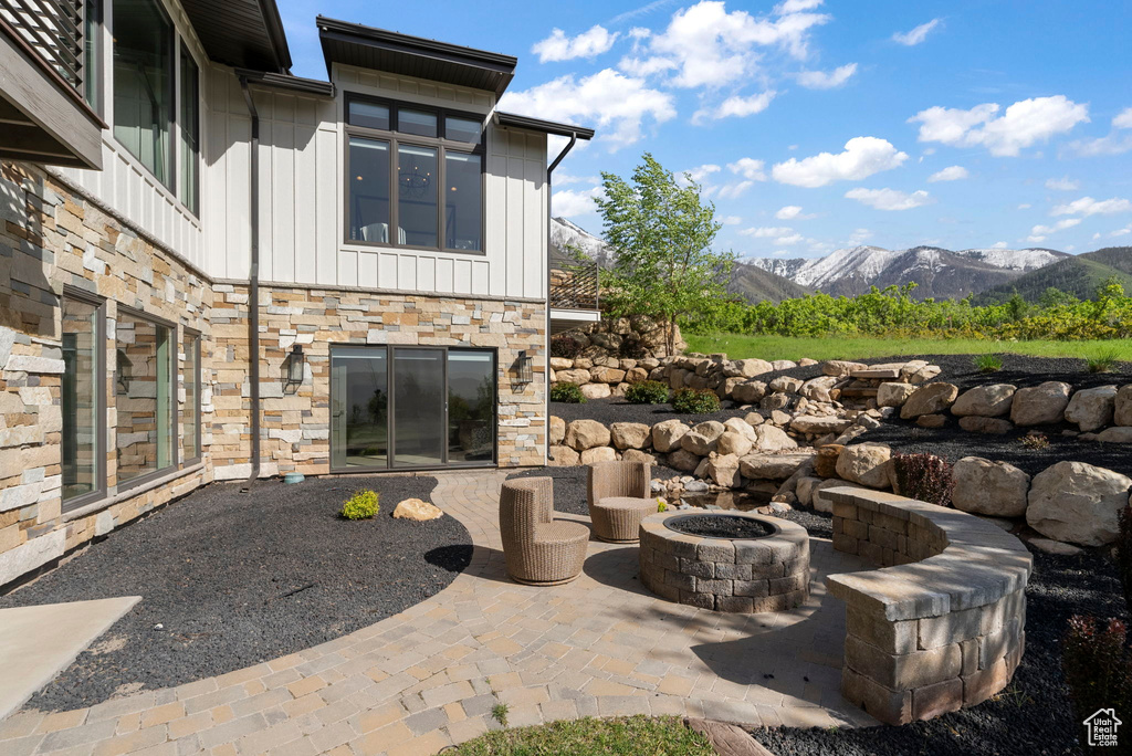 View of patio featuring an outdoor fire pit and a mountain view