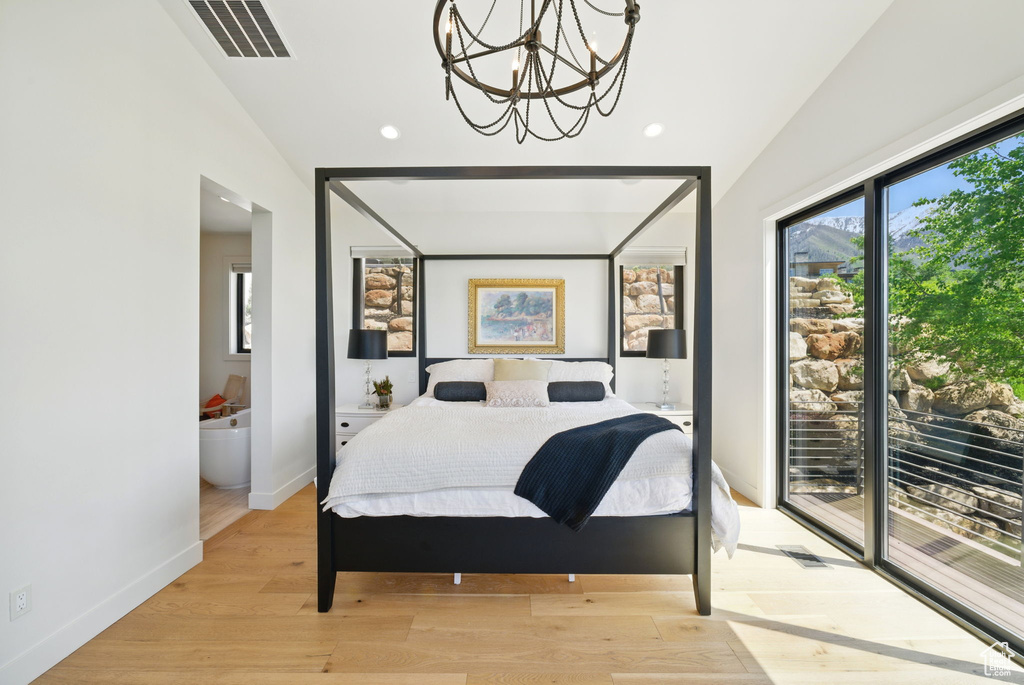 Bedroom with vaulted ceiling, access to outside, a chandelier, recessed lighting, and light wood-style floors