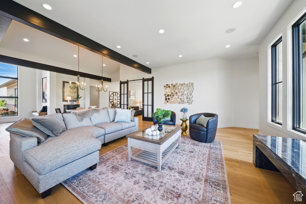 Living area featuring recessed lighting, light wood-style flooring, a chandelier, and a barn door