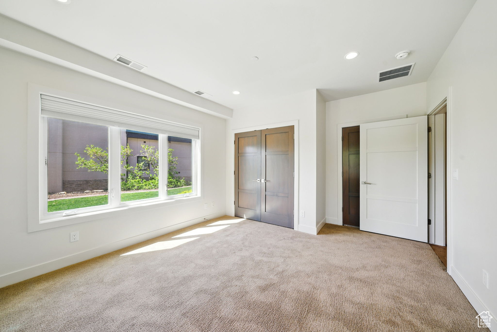Unfurnished bedroom with light carpet, baseboards, a closet, and recessed lighting