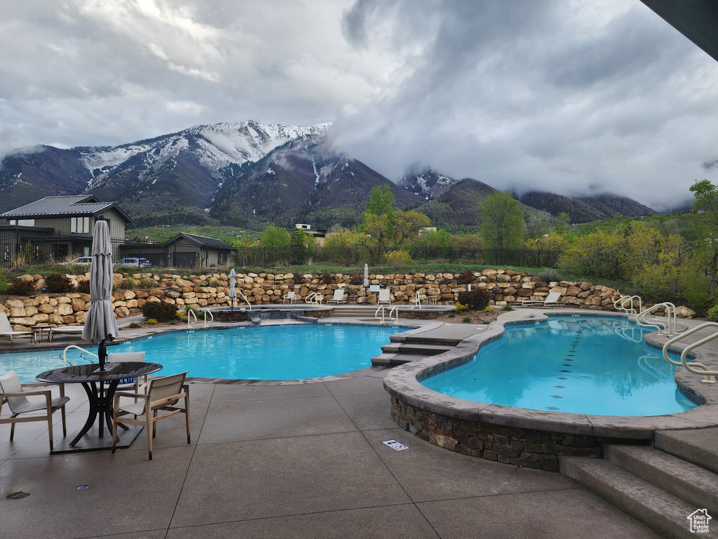 Community pool featuring a mountain view and a patio