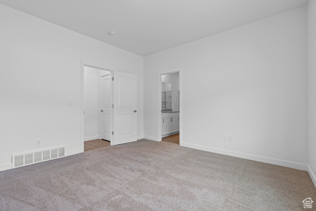 Unfurnished bedroom with carpet, baseboards, and ensuite bath
