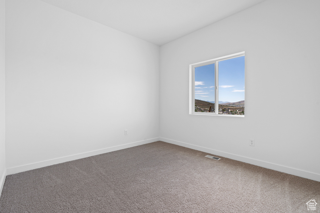 Empty room with carpet and baseboards