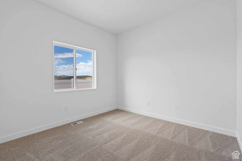 Carpeted spare room with baseboards