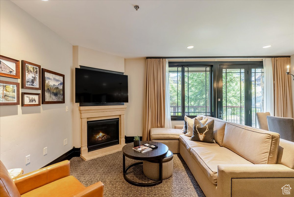 Living room featuring a glass covered fireplace and recessed lighting
