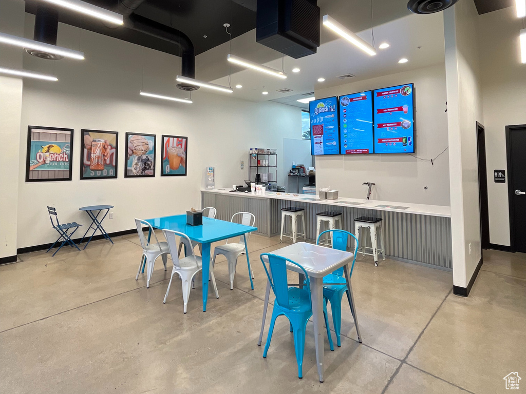 Game room featuring finished concrete flooring and a high ceiling
