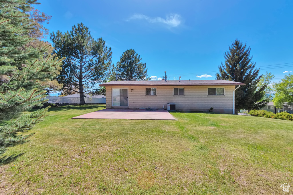 Back of property with a patio, central AC unit, and brick siding