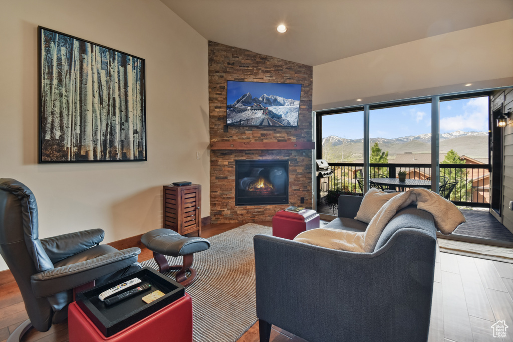 Living area with wood finished floors, a fireplace, and high vaulted ceiling