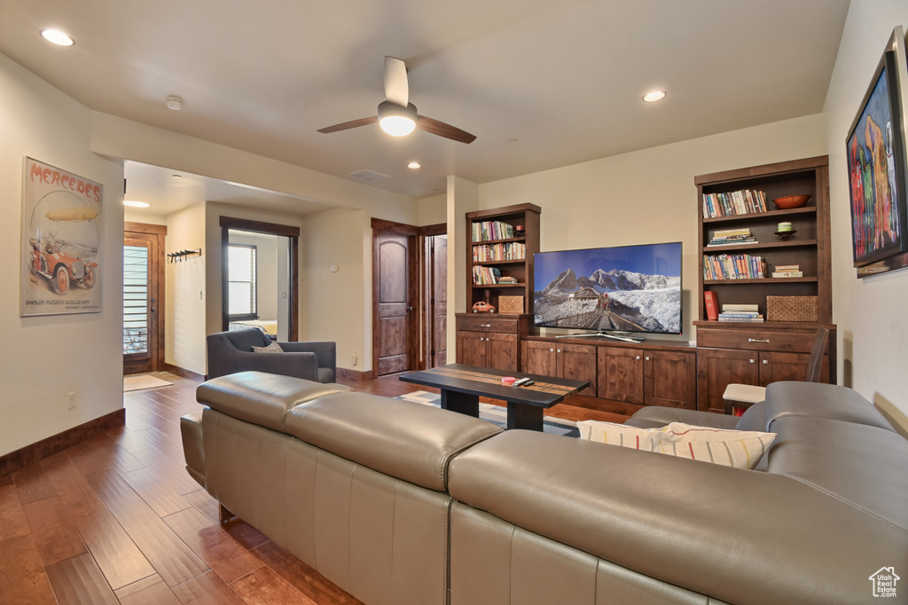 Living area featuring baseboards, ceiling fan, wood finished floors, and recessed lighting