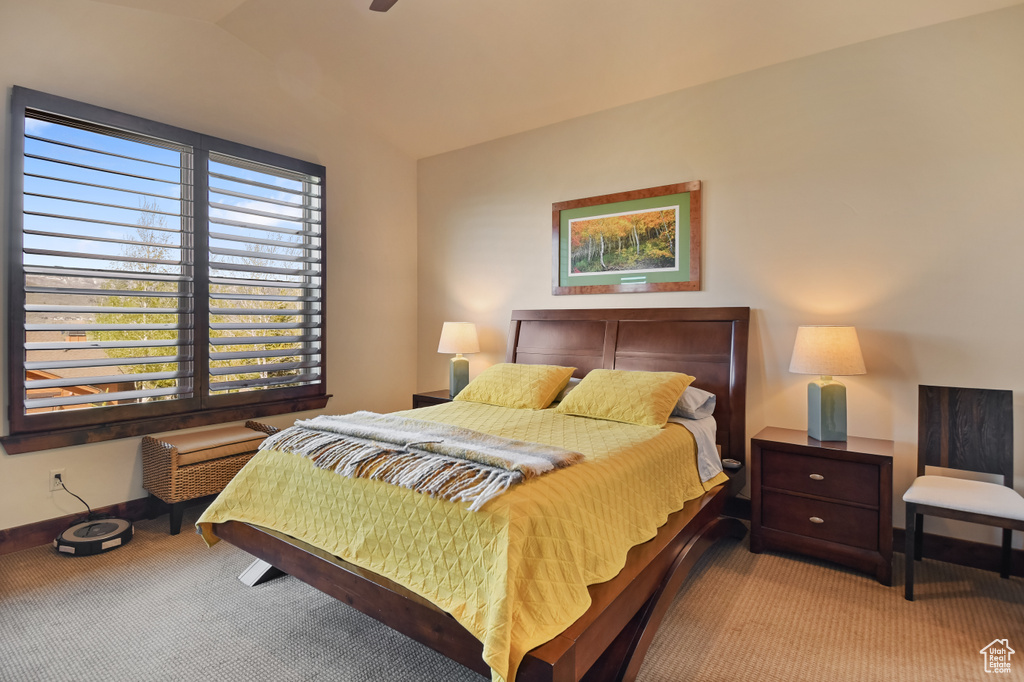Bedroom featuring light colored carpet, lofted ceiling, and baseboards
