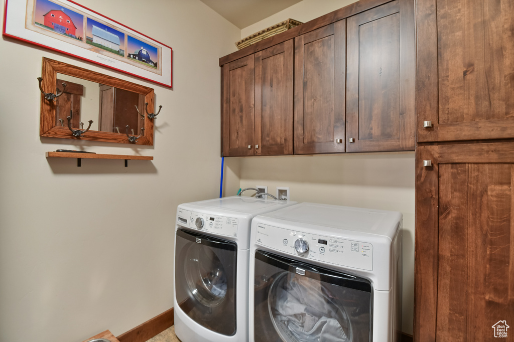Laundry room with cabinet space, washer and clothes dryer, and baseboards