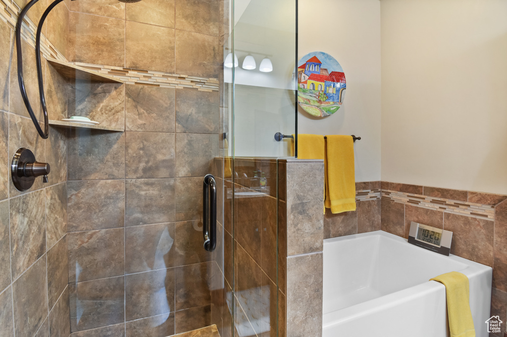 Full bath featuring a stall shower and a garden tub