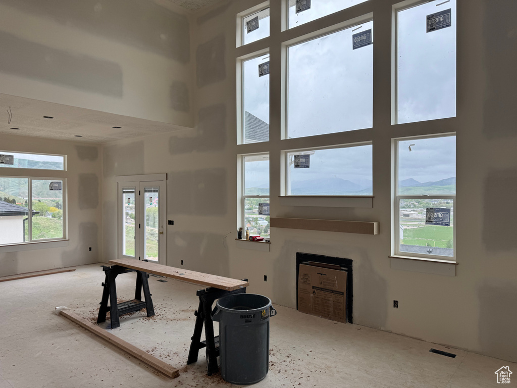 Rec room with a high ceiling and a fireplace