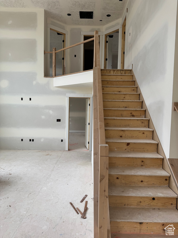 Stairway featuring a towering ceiling