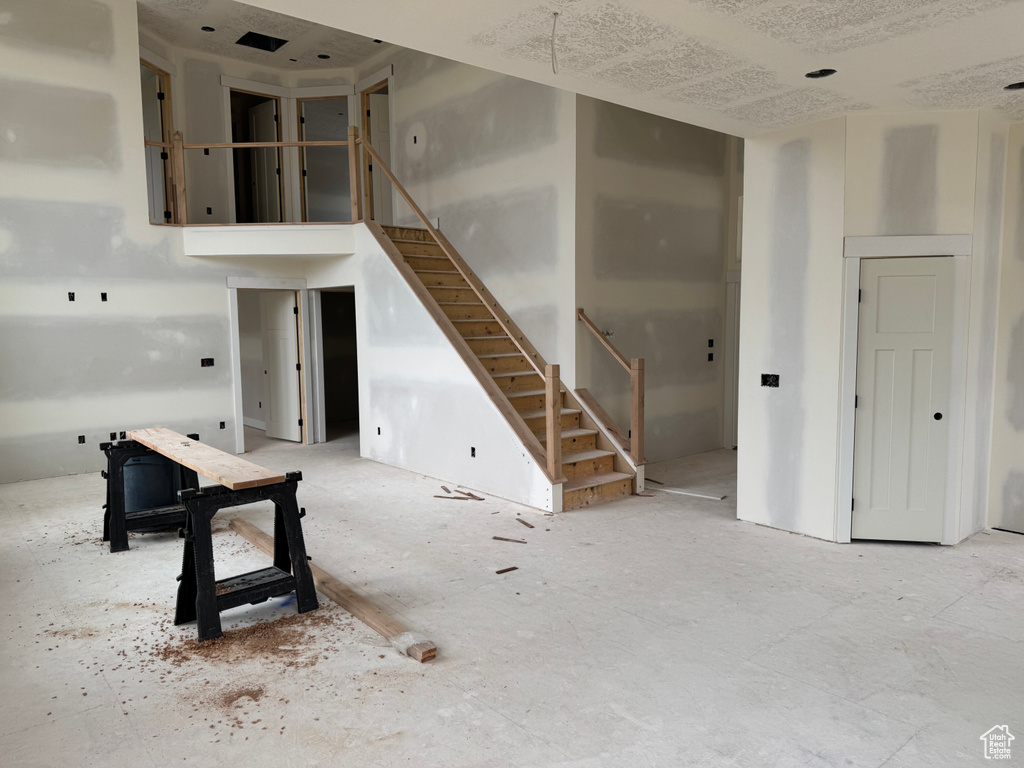 Unfurnished living room featuring stairway