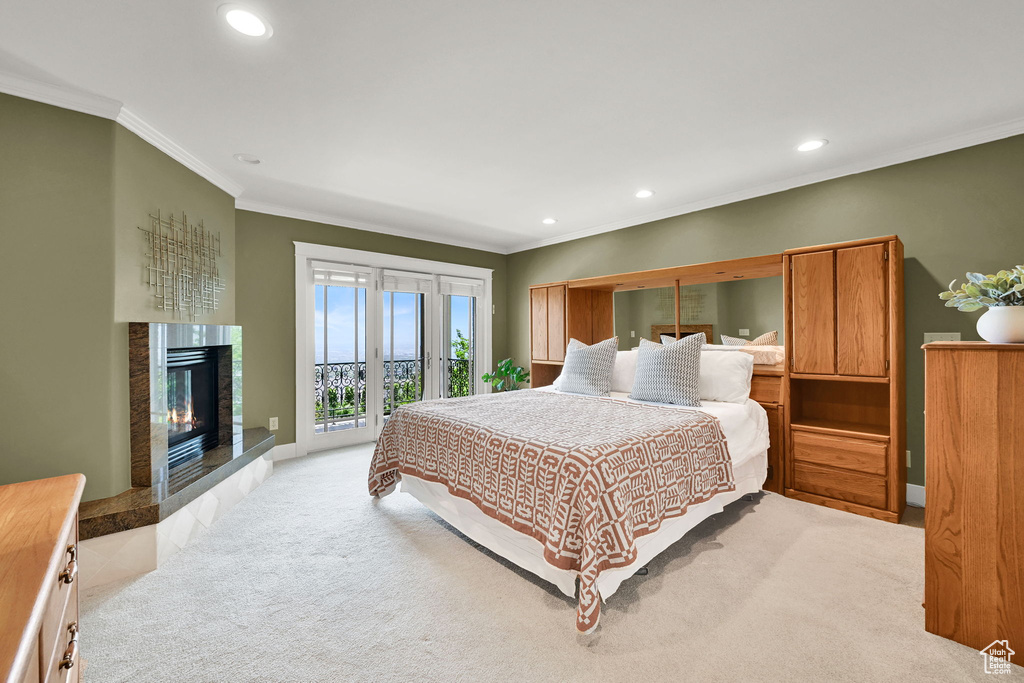 Bedroom with ornamental molding, access to exterior, light carpet, recessed lighting, and a fireplace