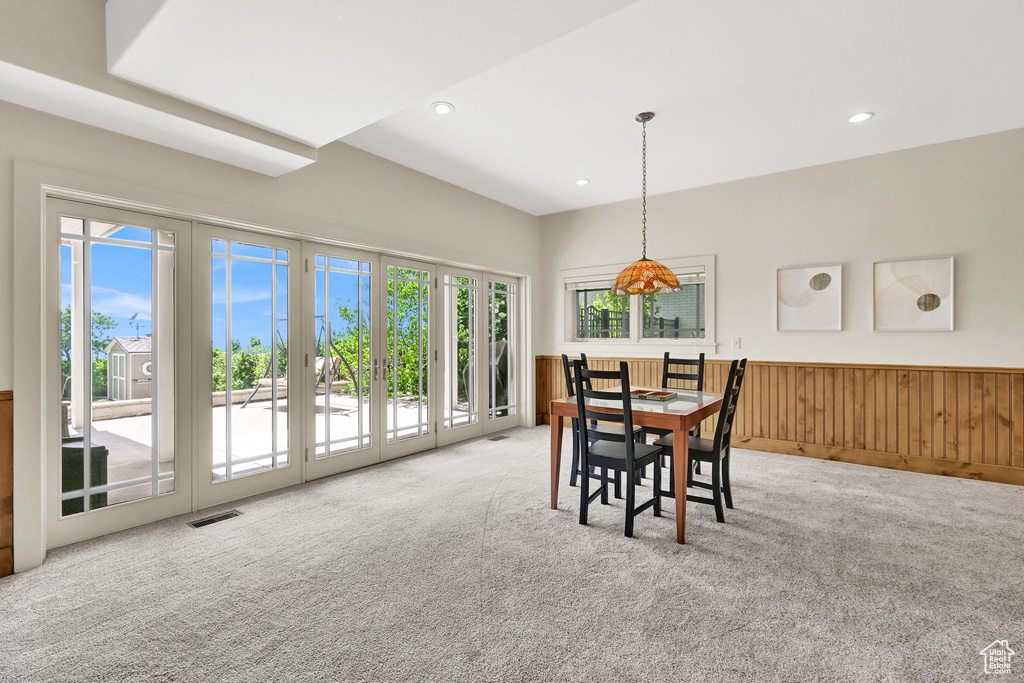 Carpeted dining space with wainscoting and recessed lighting