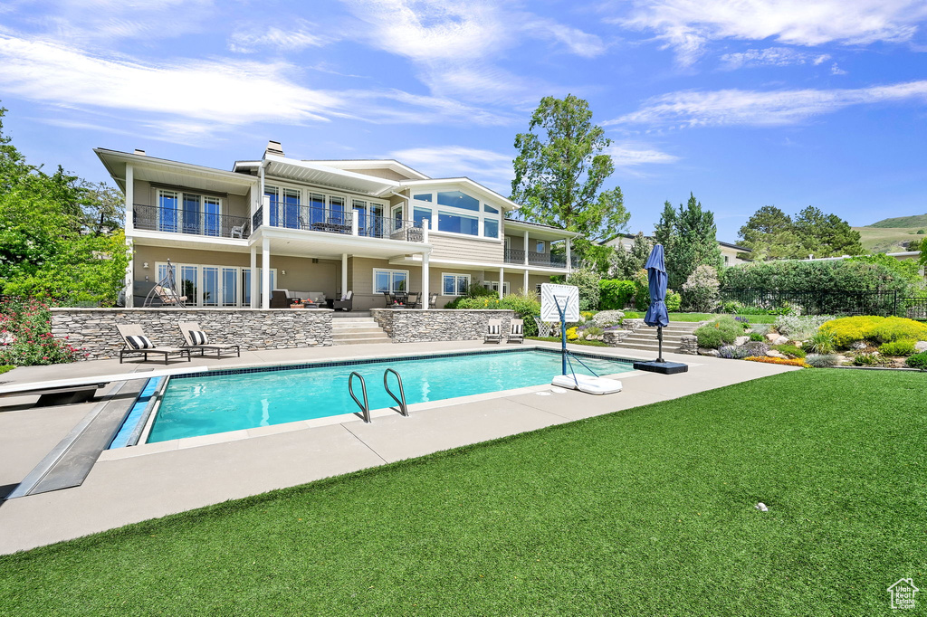 Swimming pool featuring a patio area and a lawn