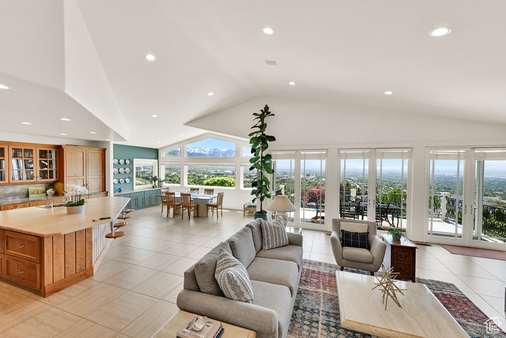Living room with recessed lighting, light tile patterned floors, and high vaulted ceiling