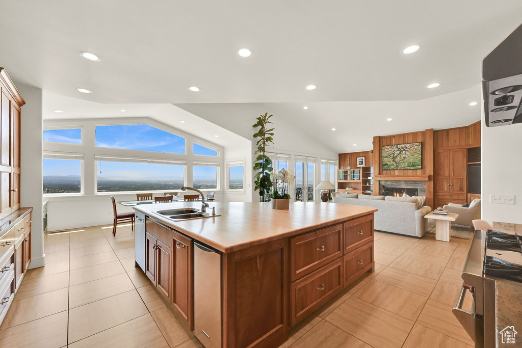 Kitchen with a sink, vaulted ceiling, dishwasher, recessed lighting, and a kitchen island with sink