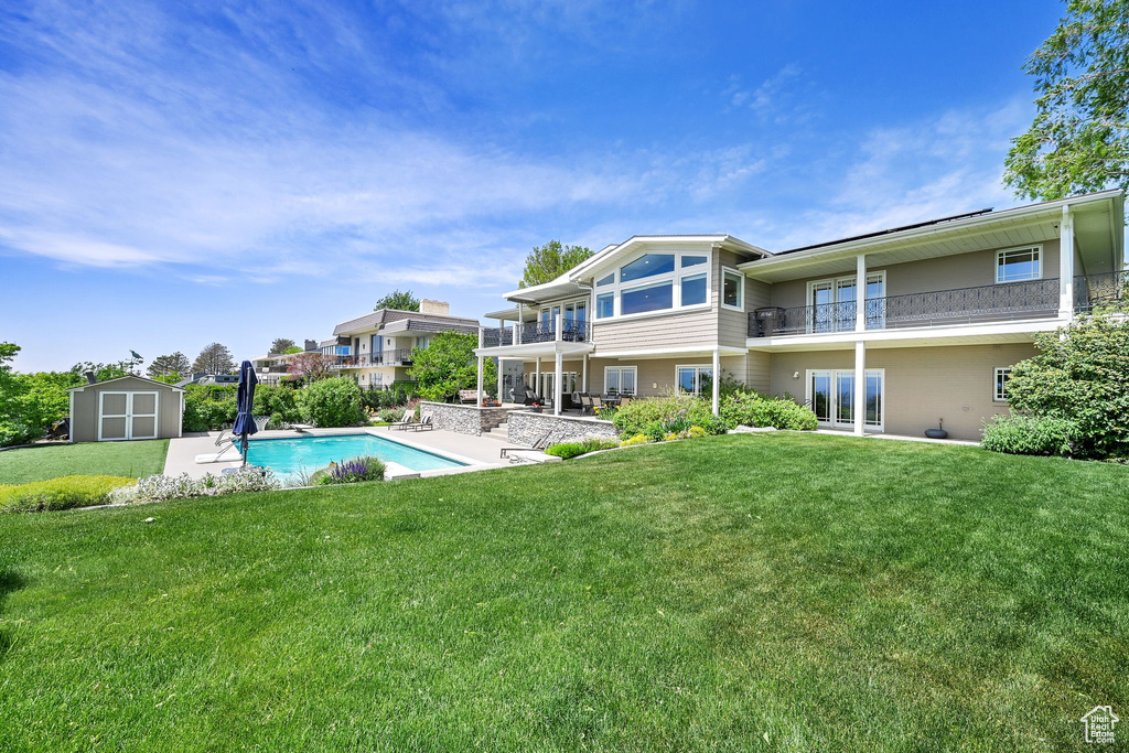 Outdoor pool featuring a storage shed, an outdoor structure, a yard, and a patio