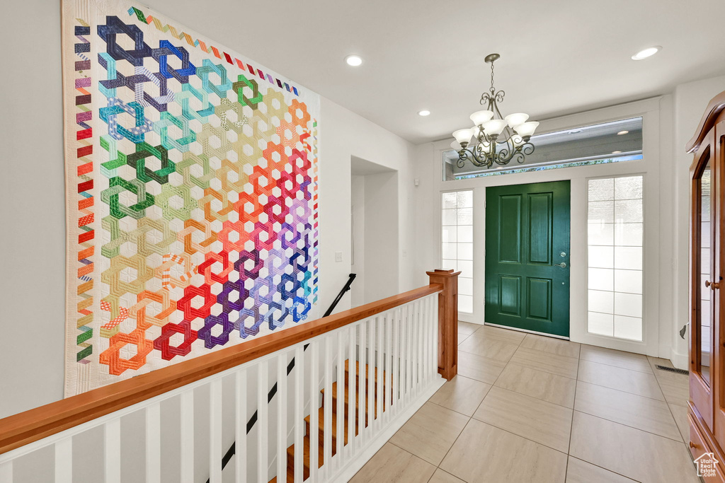 Tiled entryway featuring a chandelier and recessed lighting