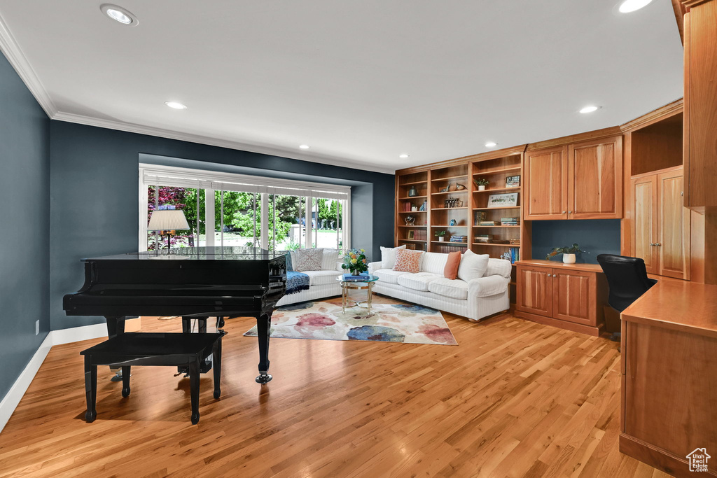 Living area featuring crown molding, light wood-style flooring, recessed lighting, and baseboards