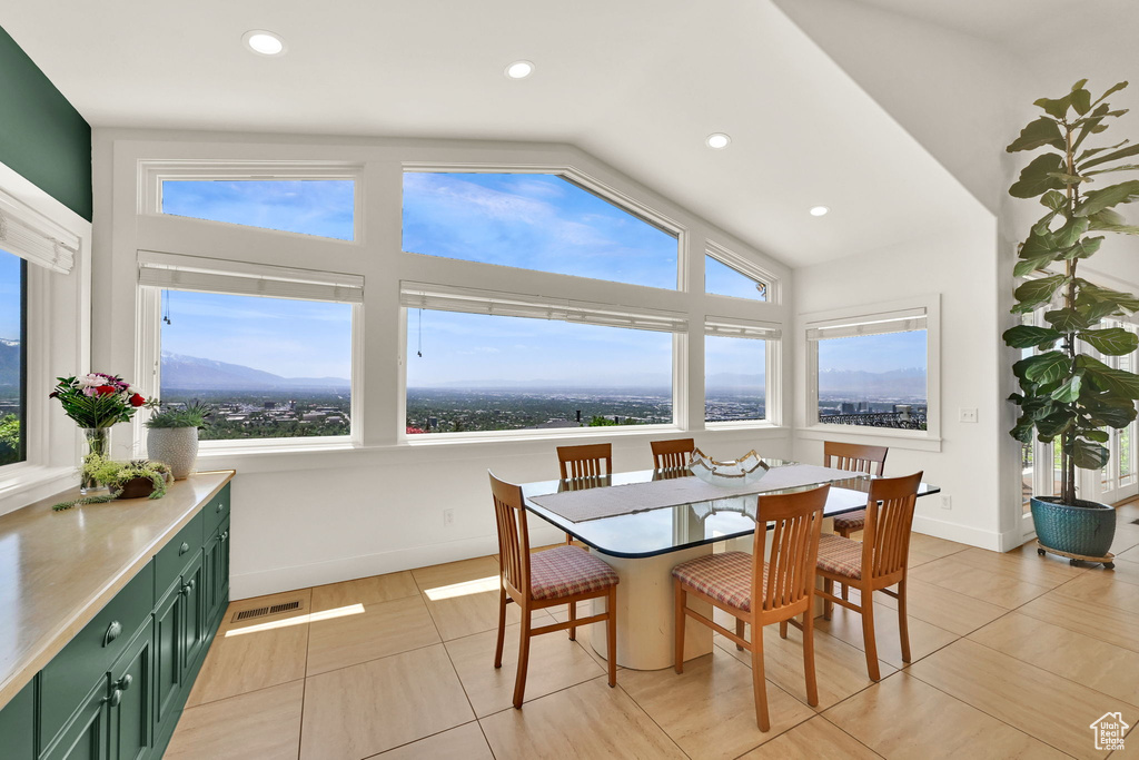 Dining space with vaulted ceiling, recessed lighting, light tile patterned floors, and baseboards