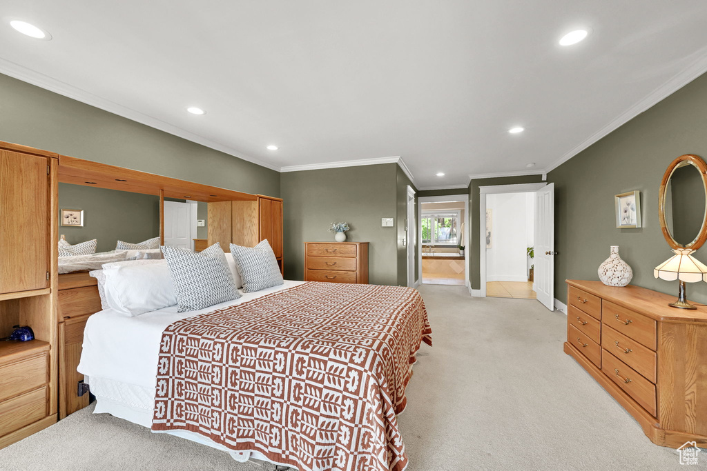 Bedroom with light colored carpet, ornamental molding, recessed lighting, and baseboards