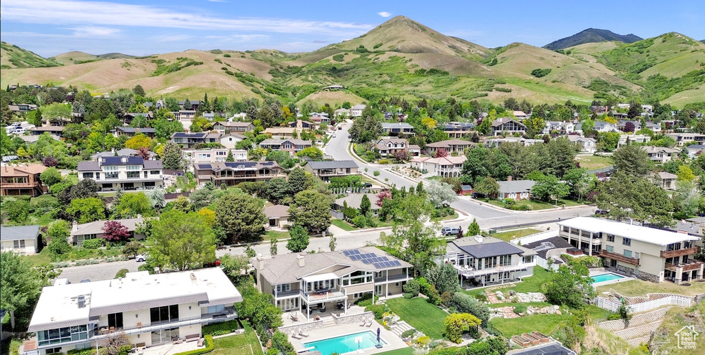 Aerial perspective of suburban area featuring a pool and mountains