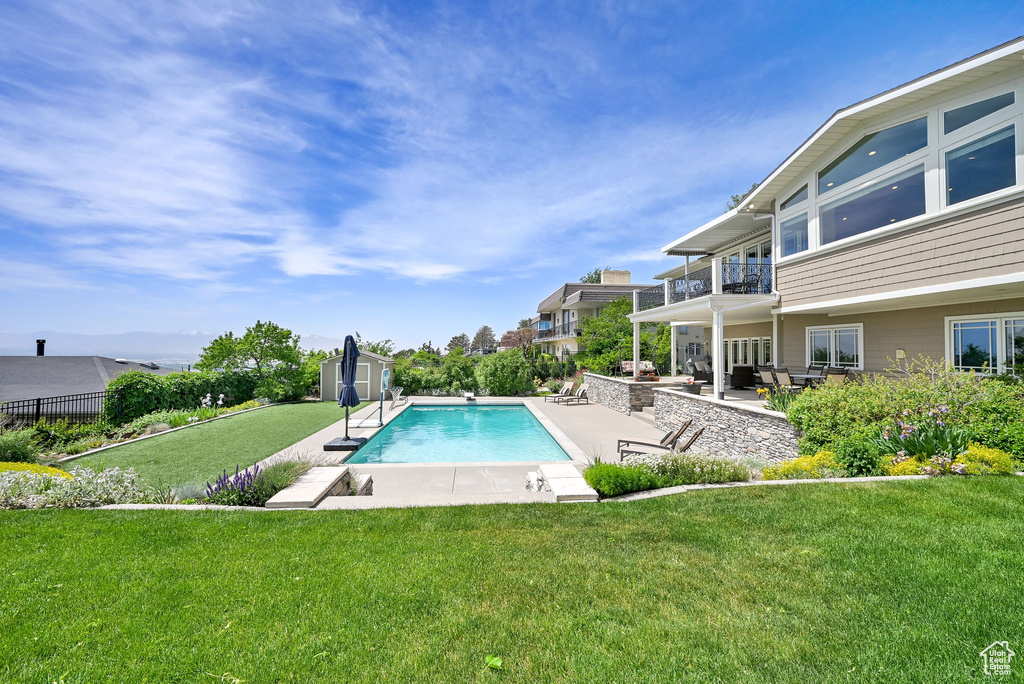 View of pool with a patio, a storage shed, and an outdoor structure