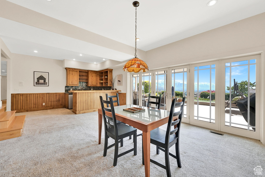 Dining area with light colored carpet, recessed lighting, french doors, and bar