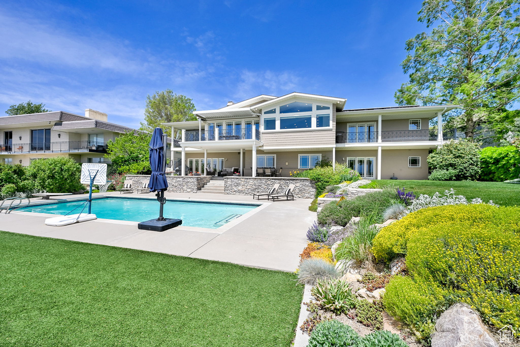 Swimming pool with a patio area and a lawn
