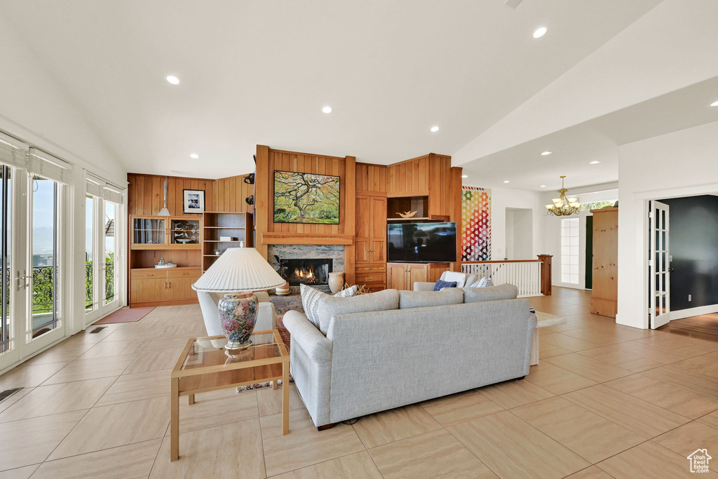 Living area with lofted ceiling, plenty of natural light, a chandelier, recessed lighting, and a fireplace