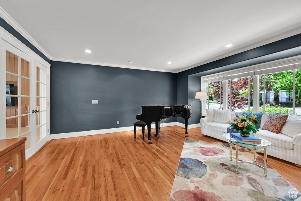 Sitting room with crown molding, light wood-style flooring, recessed lighting, baseboards, and french doors