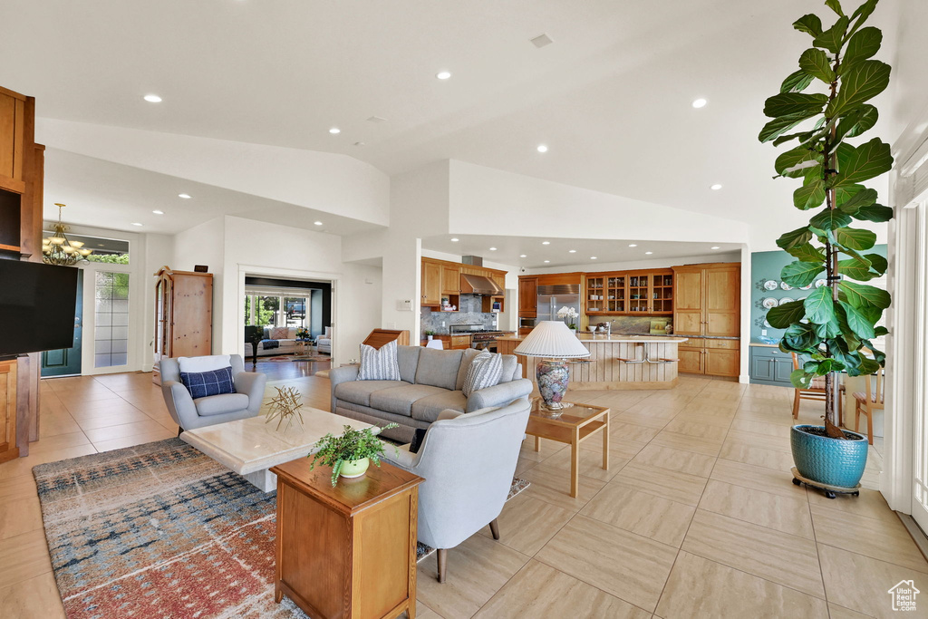 Living area with recessed lighting, a chandelier, and high vaulted ceiling