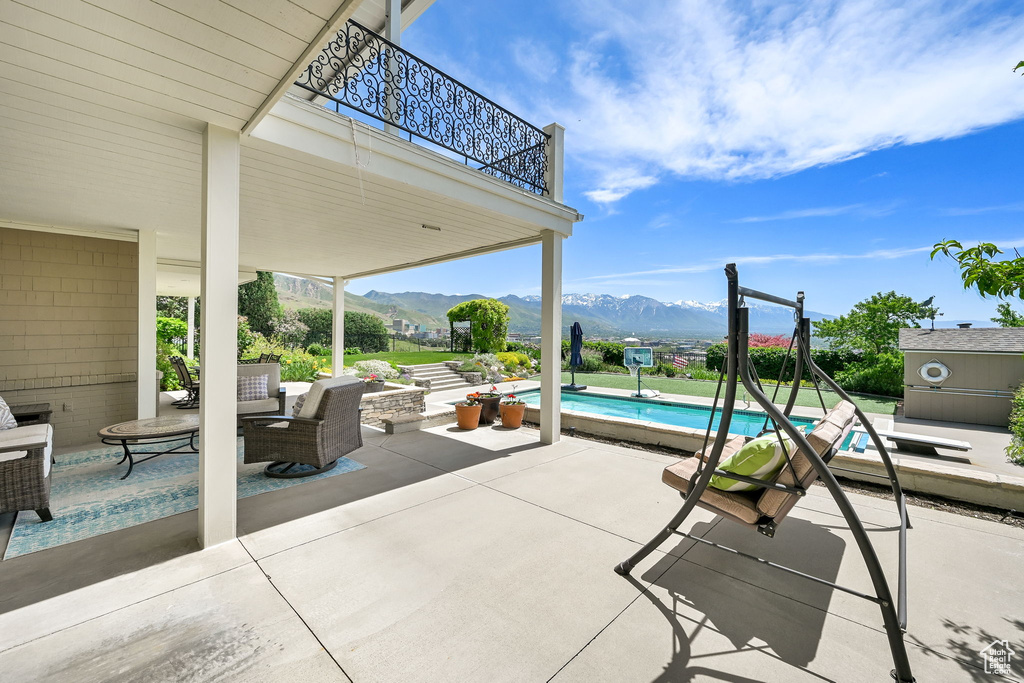View of patio featuring a balcony, a mountain view, and an outdoor pool