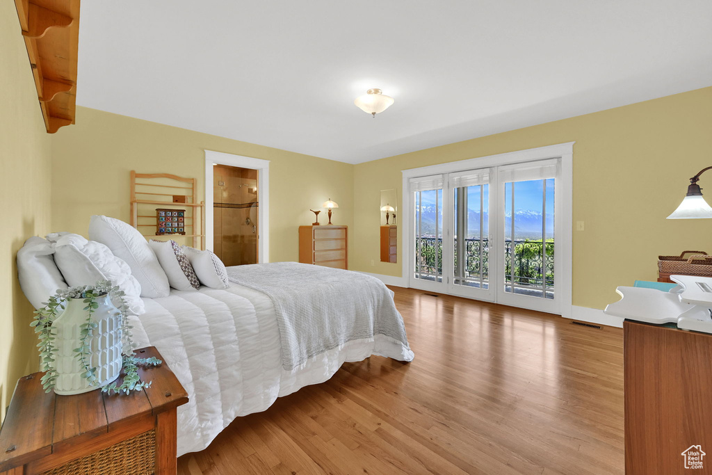 Bedroom featuring access to exterior, wood finished floors, and baseboards