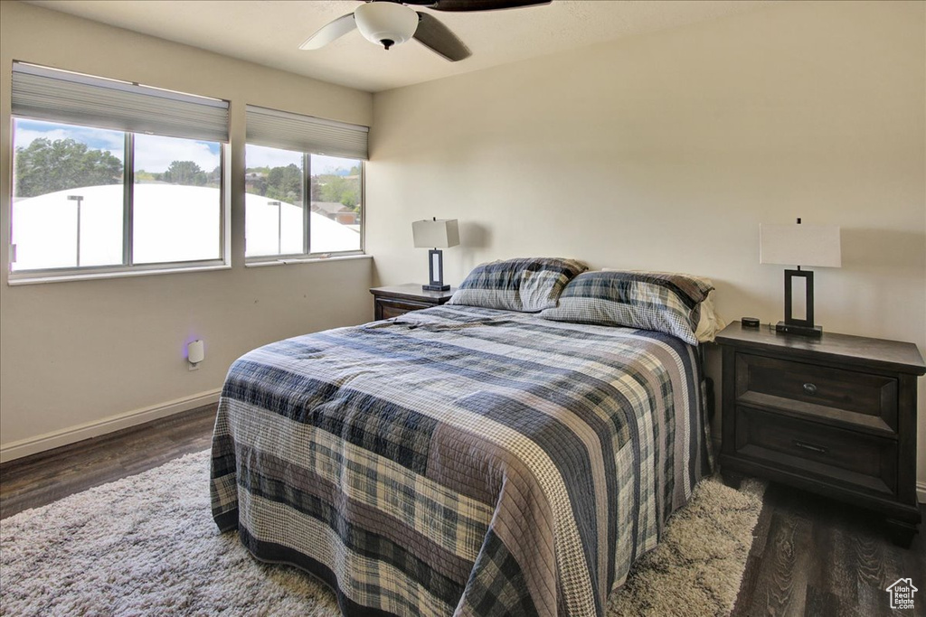 Bedroom featuring wood finished floors, baseboards, and a ceiling fan