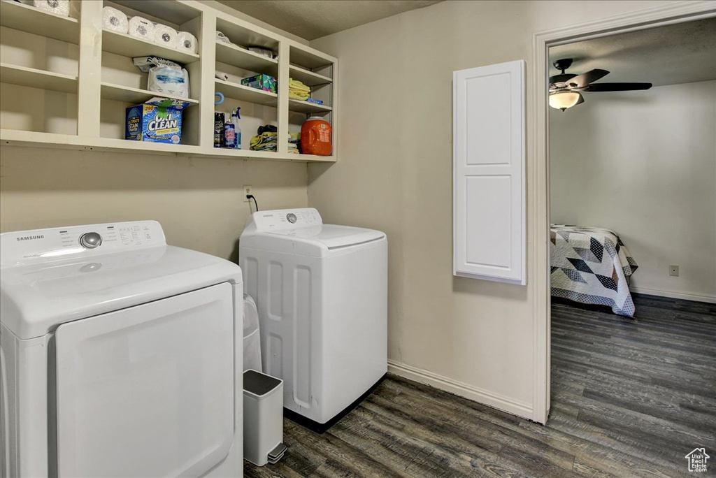 Laundry area with washing machine and clothes dryer, dark wood-type flooring, baseboards, and a ceiling fan