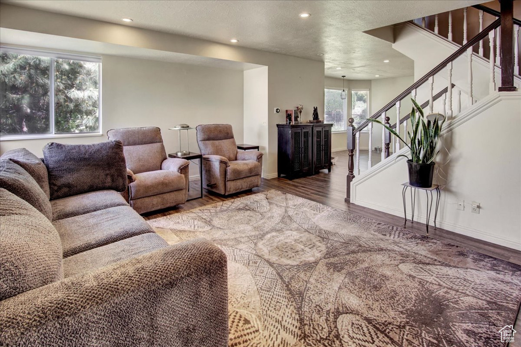 Living room featuring wood finished floors, stairway, recessed lighting, and baseboards