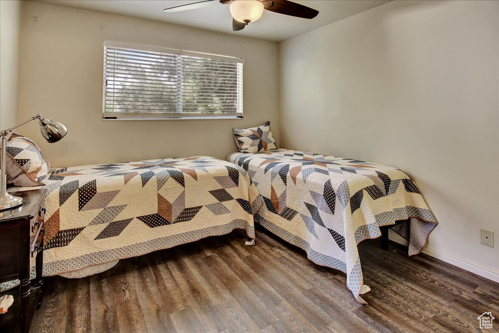 Bedroom with wood finished floors, ceiling fan, and baseboards
