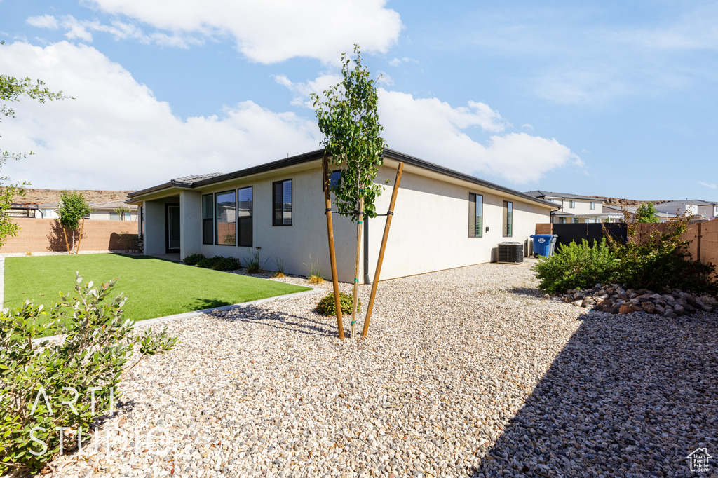 Rear view of house featuring stucco siding and central air condition unit