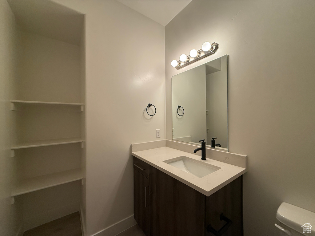 Bathroom with vanity, toilet, and baseboards