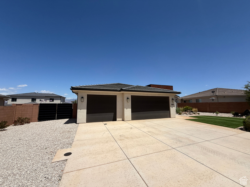 Garage with concrete driveway and fence