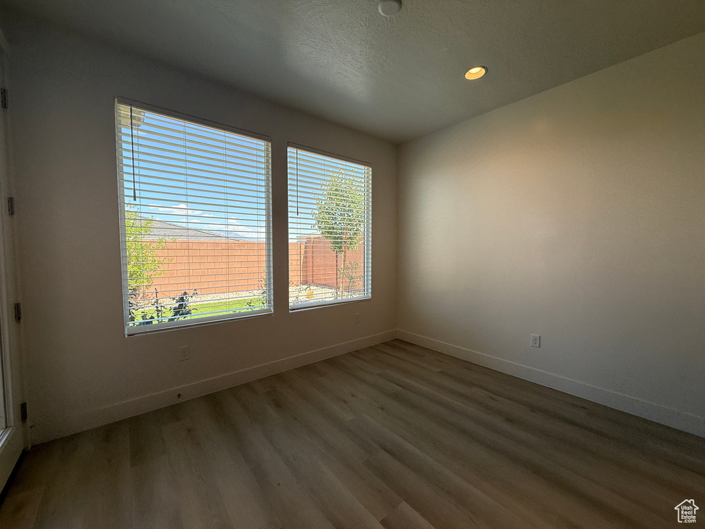 Spare room featuring wood finished floors, baseboards, and recessed lighting