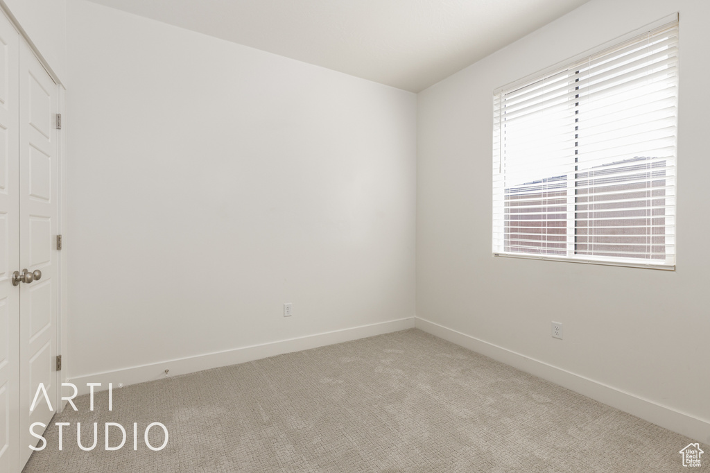 Spare room with light carpet and baseboards