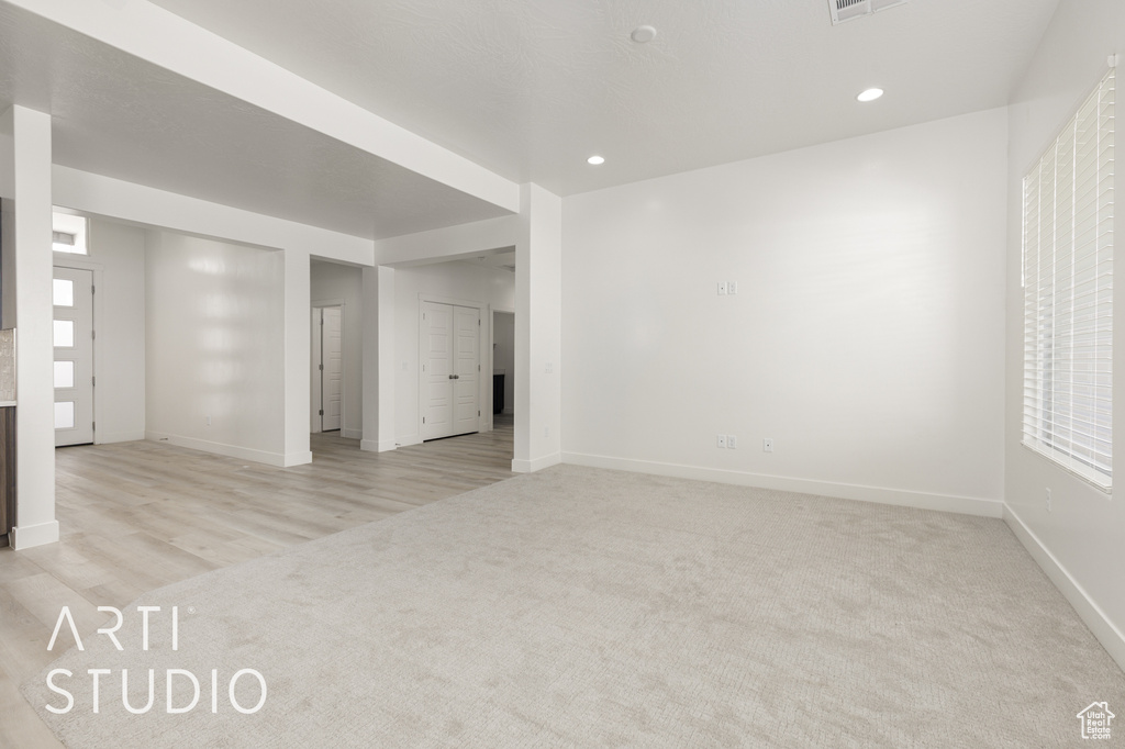 Spare room with light carpet, baseboards, and recessed lighting