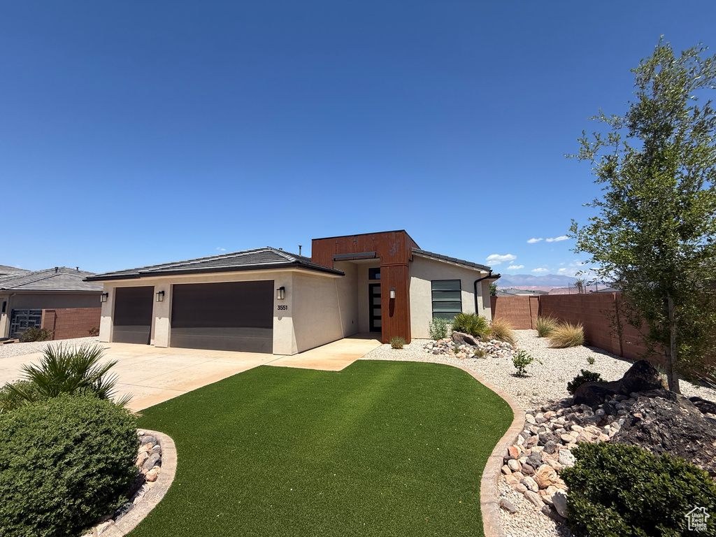 View of front of house featuring stucco siding, driveway, and a garage